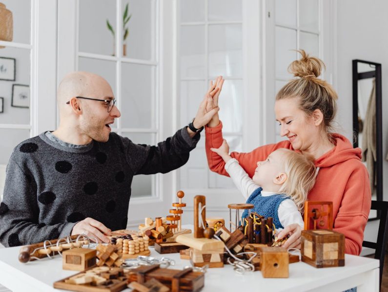 Happy Family with Child Playing Wooden Games Together